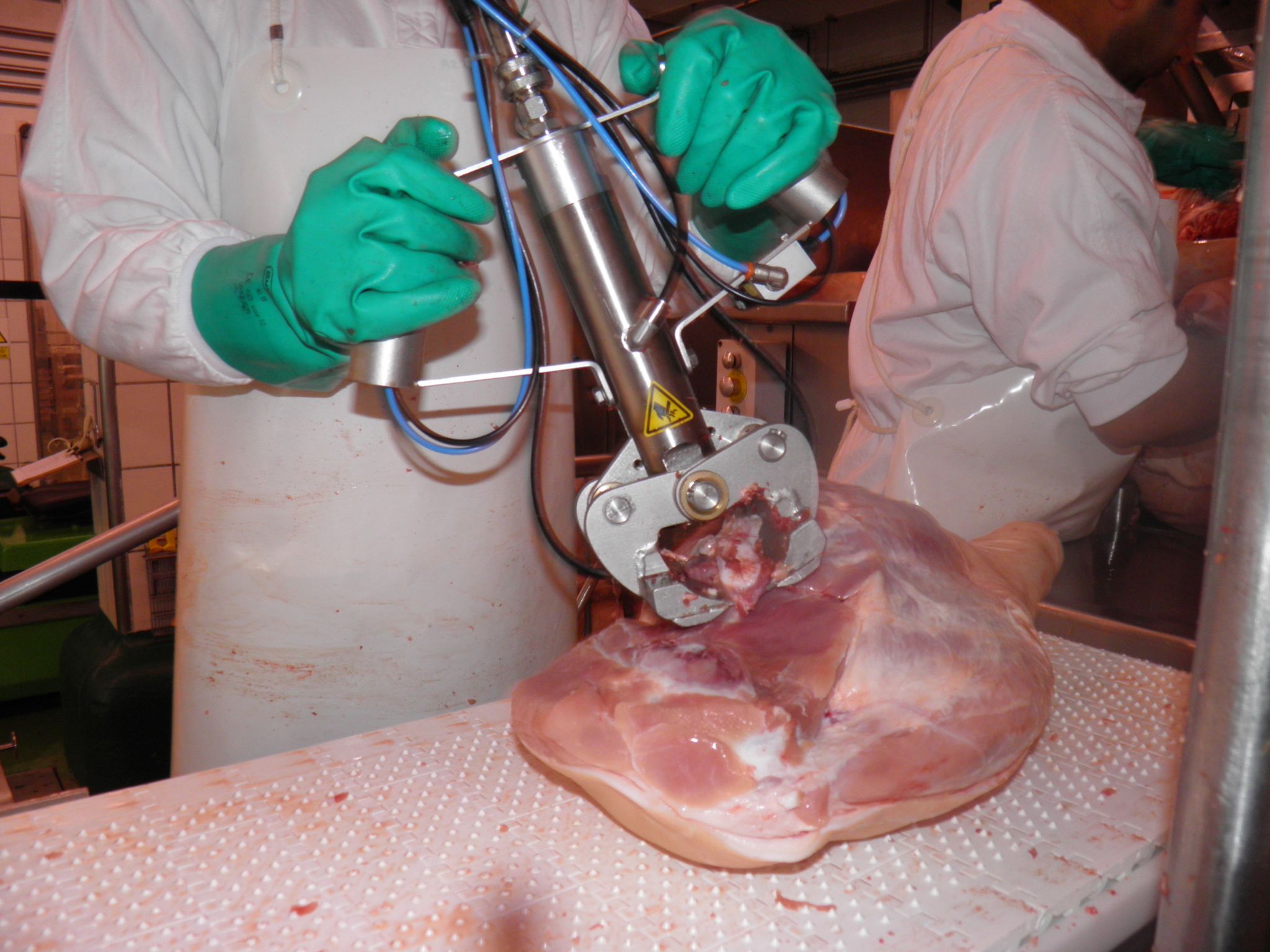 Cizalla CZ en uso sobre jamón, operario sujetando el equipo